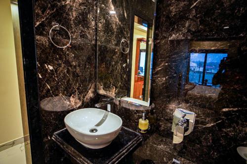 a black marble bathroom with a sink and a mirror at Gogol Beach Resort !! Beach 1 Minute !! in Mandarmoni