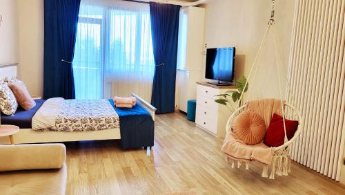 ein Schlafzimmer mit einem Schaukelbett und einem Stuhl in der Unterkunft Jasmine Residence Studios in Braşov