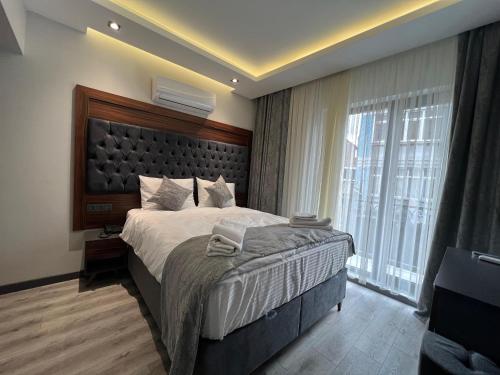 a bedroom with a large bed and a large window at Golden Stoneluxe İstanbul Hotel in Istanbul
