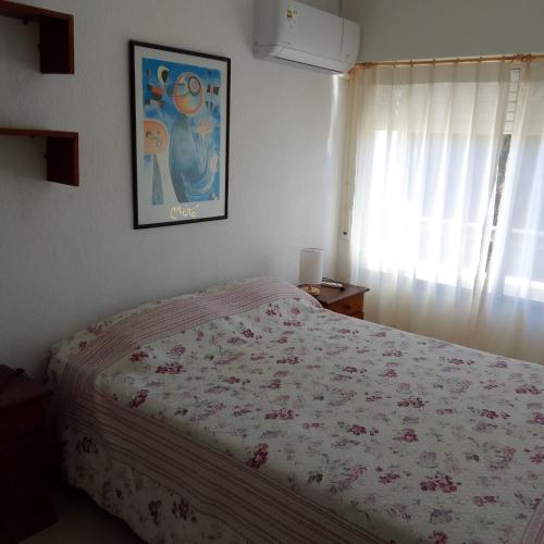 a bedroom with a bed and a picture on the wall at MAR DEL ESTE III PUNTA DEL ESTE in Punta del Este