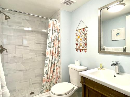 a bathroom with a toilet and a sink and a shower at Two story condo with ocean on one side and bay on other only steps away in Bradenton Beach