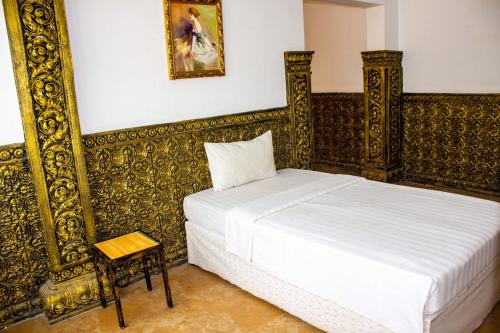 a bedroom with a bed and a side table at Le Hotel Hotel Phnom Penh in Phnom Penh