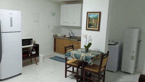 uma pequena cozinha com uma mesa e um frigorífico em Apartamento Completo A25 Flat Centro em Mogi das Cruzes