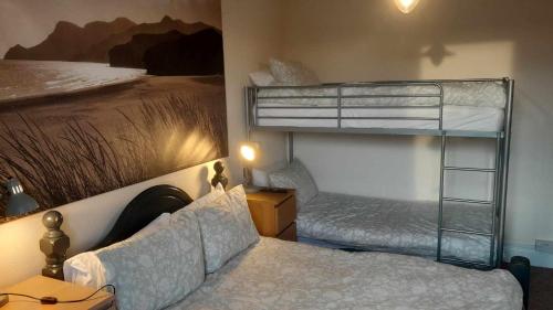a bedroom with two bunk beds and a bed at Driftwood B&B Weymouth in Weymouth