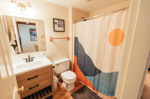 a bathroom with a sink and a toilet and a shower curtain at Newly Renovated & Furnished Condo, Only 3 min to Sunday River! in Bethel