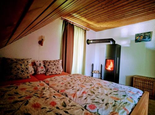 - une chambre avec un lit et un poêle à bois dans l'établissement Haus-Daxberg-idyllisch-gelegen-im-Bayerischen-Wald, à Eppenschlag