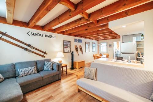 ein Wohnzimmer mit einem Sofa und einer Küche in der Unterkunft Newly Renovated & Furnished Condo, Only 3 min to Sunday River! in Bethel