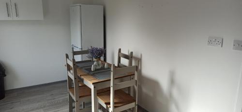 a room with a table and chairs with flowers on it at Broxtowe house -3 bed House parking Nottingham in Nottingham