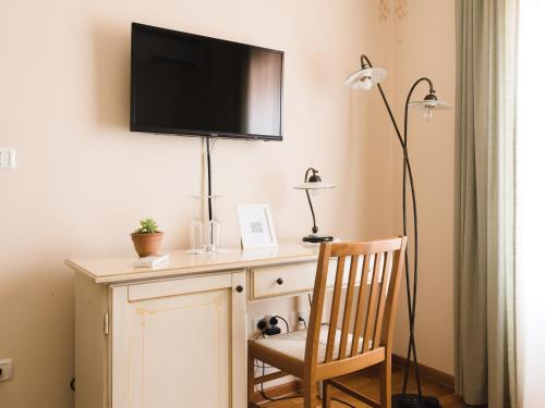 a desk with a television on a wall with a chair at Špacapanova hiša in Komen