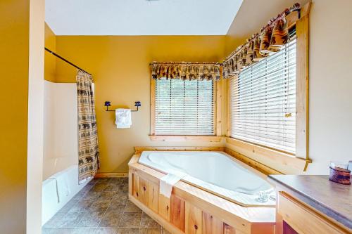 La grande salle de bains est pourvue d'une baignoire et d'une fenêtre. dans l'établissement Cozy Cub Cabin, à Gatlinburg