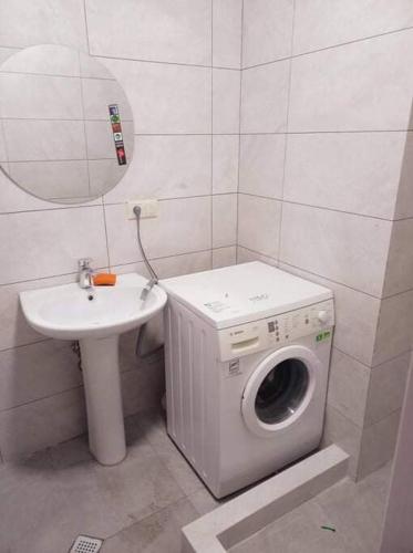 een badkamer met een wasmachine en een wastafel bij Apartment in Politovskaia st in Agaraki
