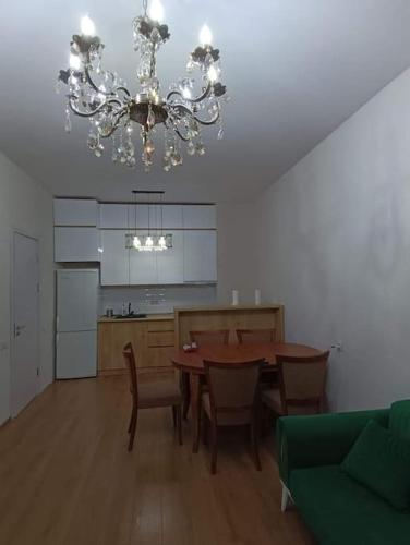 een eetkamer met een tafel en een kroonluchter bij Apartment in Politovskaia st in Agaraki