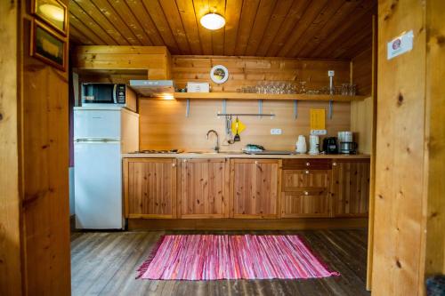 eine Küche mit einem weißen Kühlschrank und Holzschränken in der Unterkunft Chalet 3 Musketiers in Viehhofen