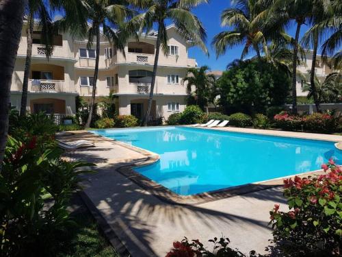 a swimming pool in front of a building at Appartment et piscine in Flic-en-Flac