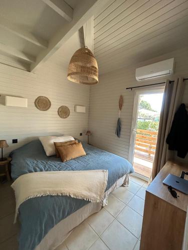 une chambre avec un lit et une grande fenêtre dans l'établissement Charmante maison californienne - jacuzzi - piscine dans le domaine - Golfe de St Tropez - 6-8 personnes, à Gassin