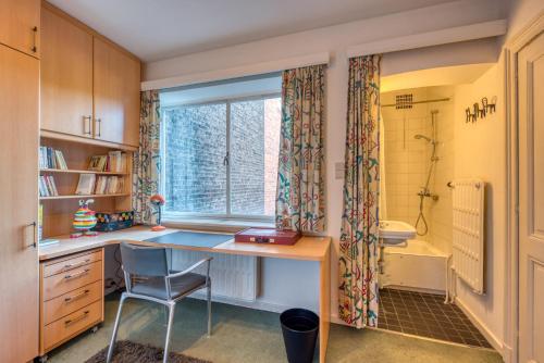 une cuisine avec un bureau, un évier et une fenêtre dans l'établissement Belle maison bourgeoise partagée de 4 logements, à Liège