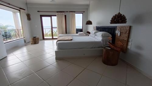 a bedroom with a bed and a tiled floor at Hotel Casa Barlovento, Parque Tayrona in Los Naranjos
