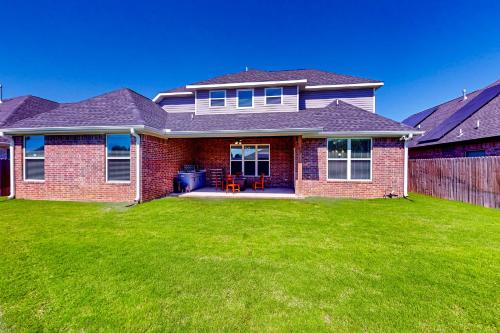a brick house with a green lawn in front of it at Life is Good on 18th Street in Bentonville