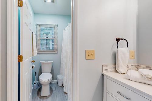 a white bathroom with a toilet and a sink at Ev's Escape, 201B in Sunset Beach