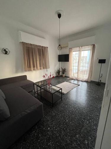 uma sala de estar com um sofá e uma mesa em Cozy Apartment in City Center. em Atenas