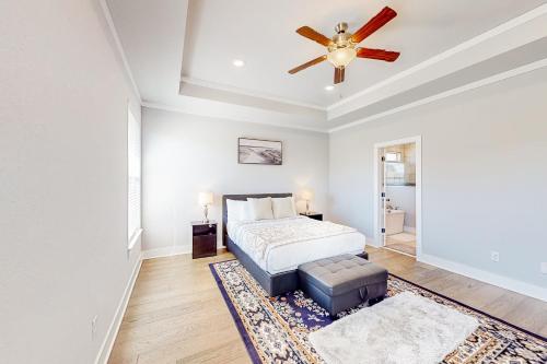 a bedroom with a bed and a ceiling fan at Life is Good on 18th Street in Bentonville