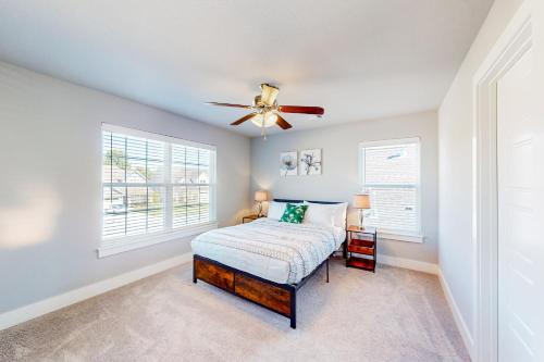 a bedroom with a bed and a ceiling fan at Life is Good on 18th Street in Bentonville