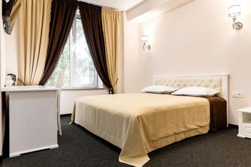 a white bedroom with a bed and a window at Zhytomyr palace mimino in Zhytomyr