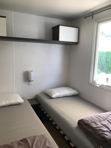 Giường trong phòng chung tại Mobil home 6 personnes dans camping 5*