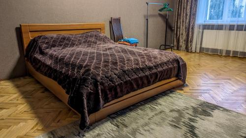 uma cama com um edredão castanho num quarto em Двухкомнатная Квартира на Пятницкой em Chernigov
