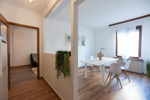 une cuisine et une salle à manger avec une table et des chaises blanches dans l'établissement Appartement cosy de 80 m2, à Mulhouse