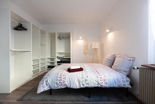 - une chambre avec un lit blanc et une boîte rouge dans l'établissement Appartement cosy de 80 m2, à Mulhouse