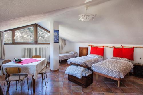 Habitación con 2 camas, mesa, mesa y sillas. en Il Faggio, en Villar San Costanzo