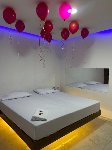 Baranoa的住宿－MOTEL SANTORINI，一间设有一张从天花板上悬挂着气球的床的房间
