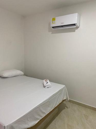 Zimmer mit einem Bett und einer Klimaanlage an der Wand in der Unterkunft MOTEL SANTORINI in Baranoa