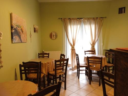 un comedor con mesas y sillas y una ventana en Guesthouse Eleftherios, en Kalavrita