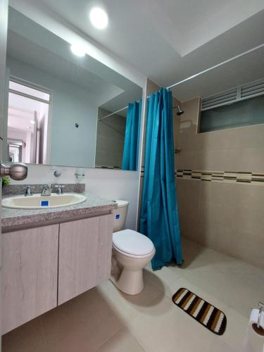 y baño con aseo, lavabo y espejo. en Aqualina Orange Hermoso Apartamento Piso 3 Vista a Piscina, en Girardot