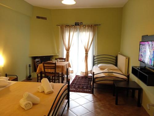 ein Wohnzimmer mit einem Esstisch und einem TV in der Unterkunft Guesthouse Eleftherios in Kalavryta