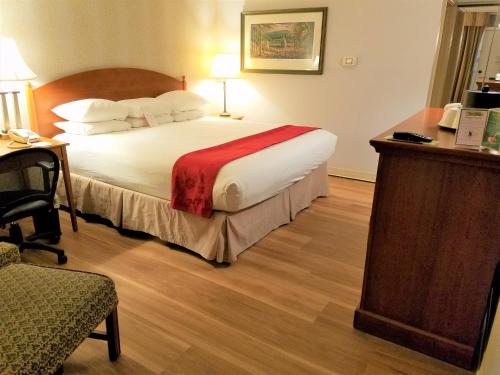 a hotel room with a bed and a desk at Ramada by Wyndham State College Hotel & Conference Center in State College