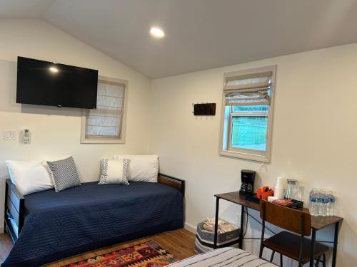 um quarto com uma cama e uma televisão na parede em Black Hills Station em Piedmont