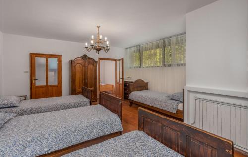 a bedroom with three beds and a chandelier at Gorgeous Home In Cabar With Kitchen in Čabar