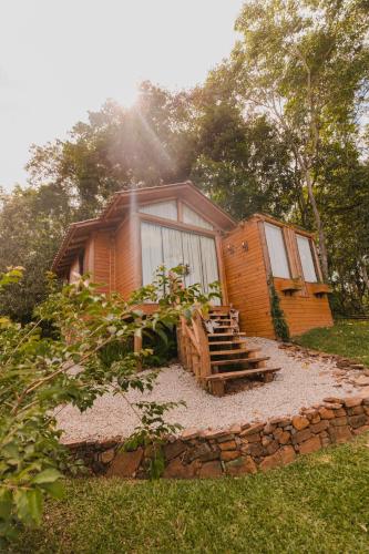 a wooden cabin with a set of stairs in the grass at La Nostra Terra in Nova Veneza