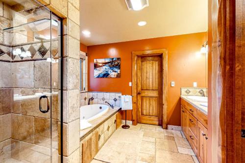 a bathroom with a tub and two sinks and a shower at Log Luxury in Tahoe Vista