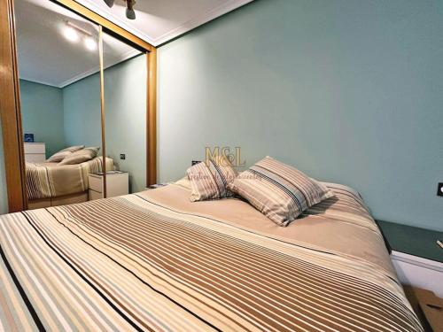 ein Schlafzimmer mit einem großen Bett und einem großen Spiegel in der Unterkunft Apartamento Hugu in Oviedo