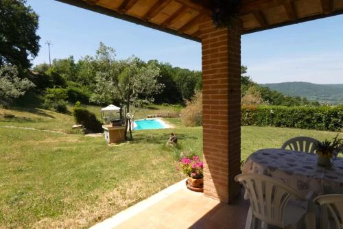 patio con mesa y vistas a la piscina en SCAPPO IN UMBRIA, il Pennacchio, en Penna in Teverina
