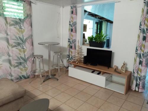 a living room with a flat screen tv on a table at Nature in Fort-de-France