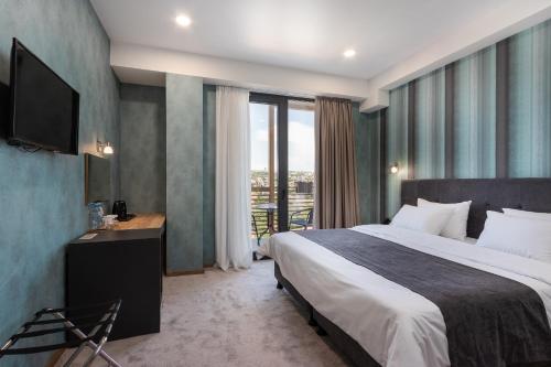 a hotel room with a bed and a television at Brooch Boutique Hotel in Tbilisi City