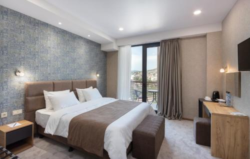 a bedroom with a large bed and a large window at Brooch Boutique Hotel in Tbilisi City