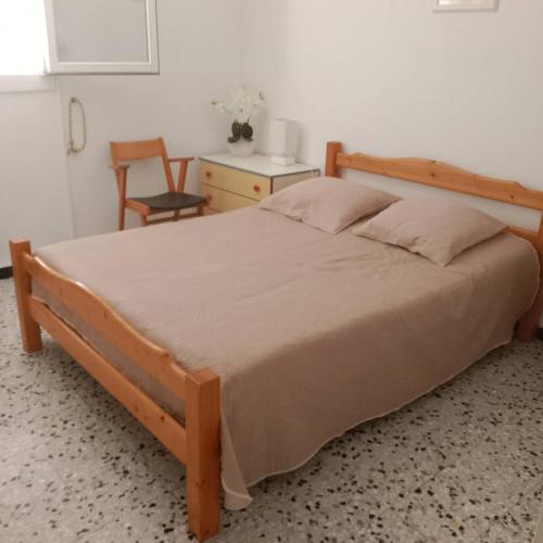 卡內的住宿－Appartement T3 centre de Canet Plage - 6SYRA10，一间卧室配有一张木床、一张桌子和一把椅子