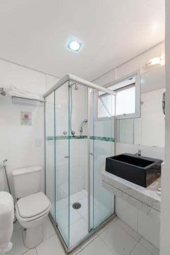 a bathroom with a toilet and a glass shower at Capcana Hotel Jardins in Sao Paulo