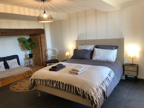 een slaapkamer met een groot bed met 2 lampen bij Appartement 4 a 6 pers entre Toulouse et Albi in Buzet-sur-Tarn